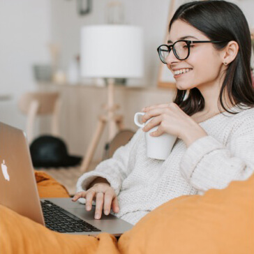 An employee smiling while working on her laptop